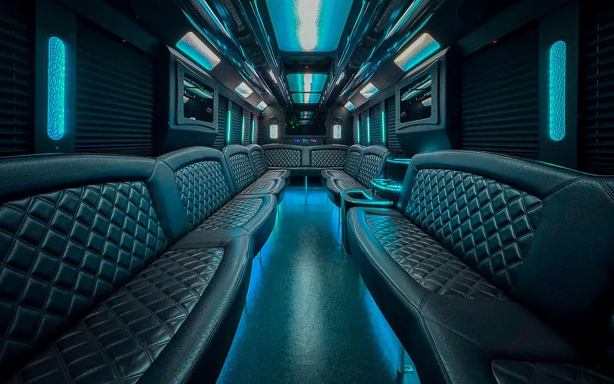Ford F-550 Party Bus interior with perimeter lounge seating, window shades and LED accent lighting for limo rental in North Attleboro, MA