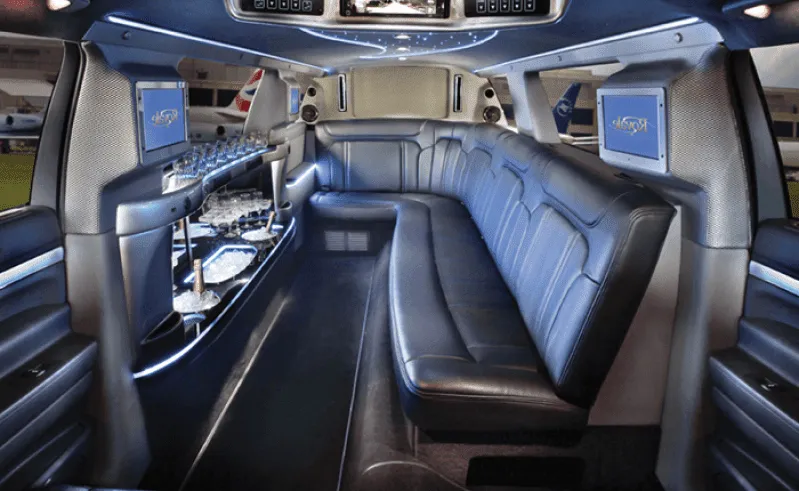 Ford Excursion Limo interior with sofa-style seating, LED accent lighting and bar area for limo rental