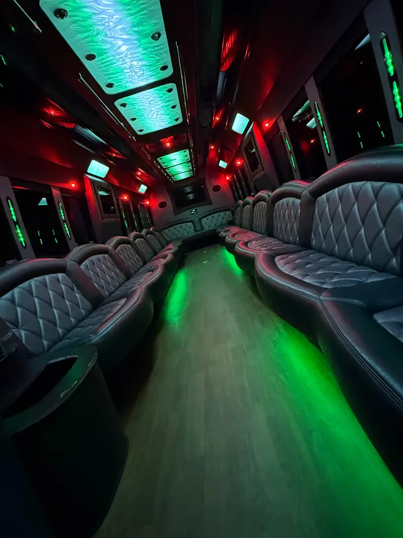 Freightliner Party Bus interior with perimeter lounge seating, LED ceiling lighting and wood-look flooring, photo 10 for limo rental in North Attleboro, MA