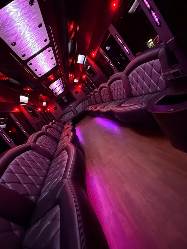 Freightliner Party Bus interior with perimeter lounge seating, LED ceiling lighting and wood-look flooring, photo 11 for limo rental in North Attleboro, MA