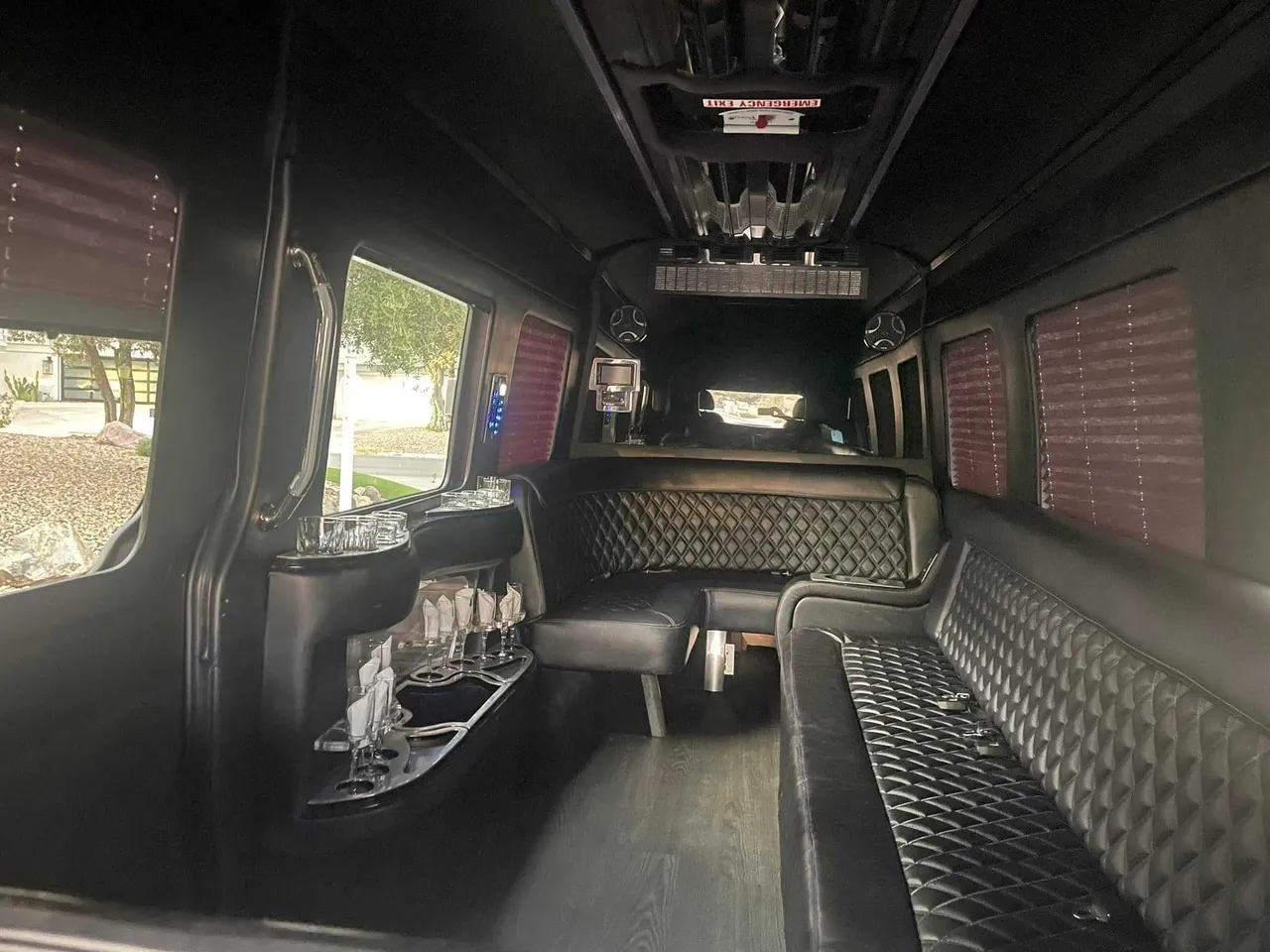 Mercedes-Benz Limousine Sprinter rental, interior view: perimeter lounge seating, window shades and bar area