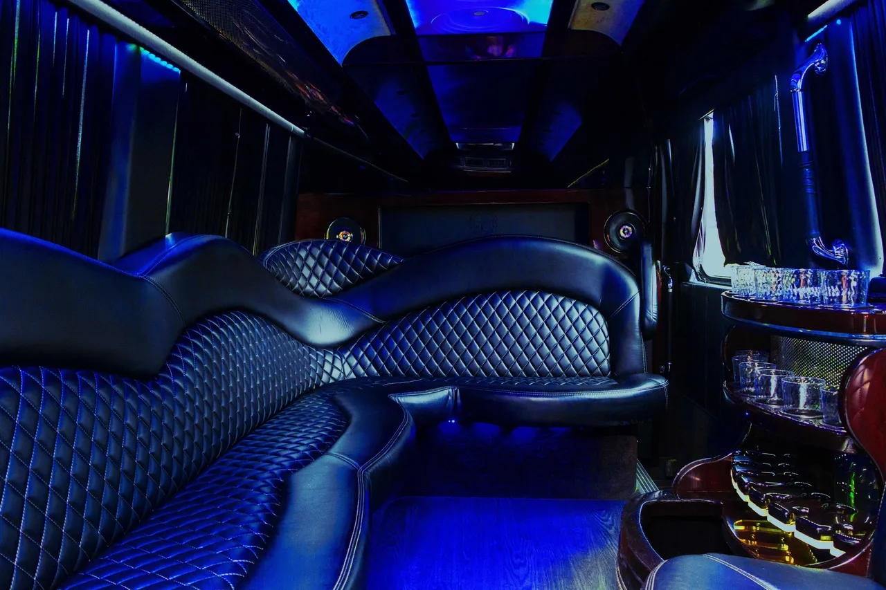 Mercedes-Benz Sprinter Limousine rental, interior view: sofa-style seating, window shades and bar area
