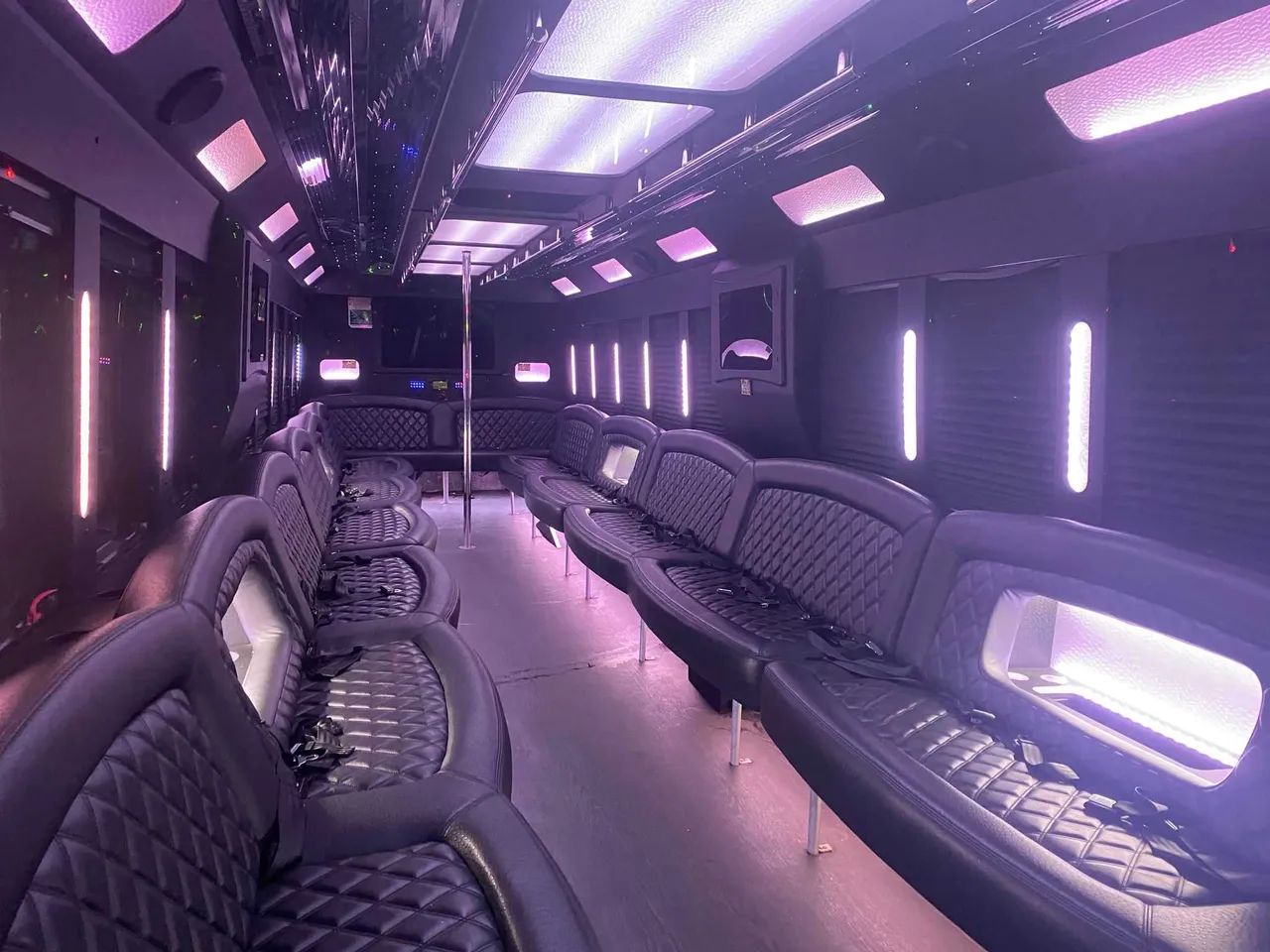 25 Passenger Party Bus interior with perimeter lounge seating, LED accent lighting and LED ceiling lighting for limo rental in South Richmond Hill, NY