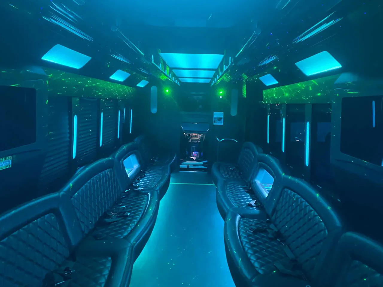 25 Passenger Party Bus interior with perimeter lounge seating, LED accent lighting and LED ceiling lighting, photo 2 for limo rental in South Richmond Hill, NY