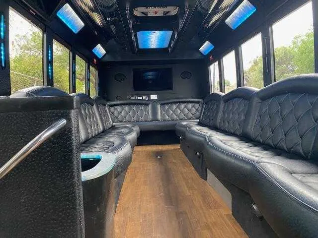 24 Passenger Party Bus limo rental, interior view: perimeter lounge seating, LED accent lighting and LED ceiling lighting