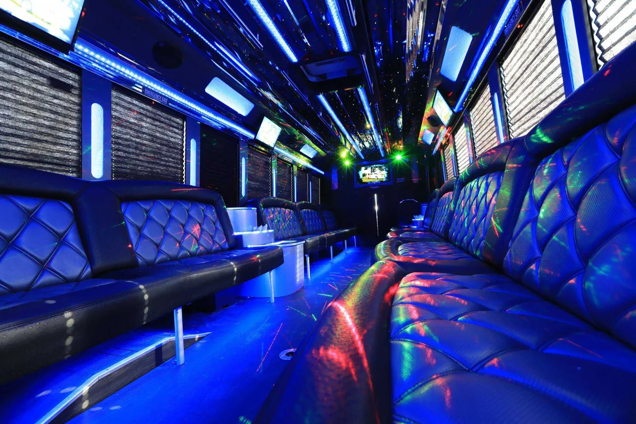30 Passenger Party Bus limo rental, interior view: perimeter lounge seating, window shades and LED accent lighting